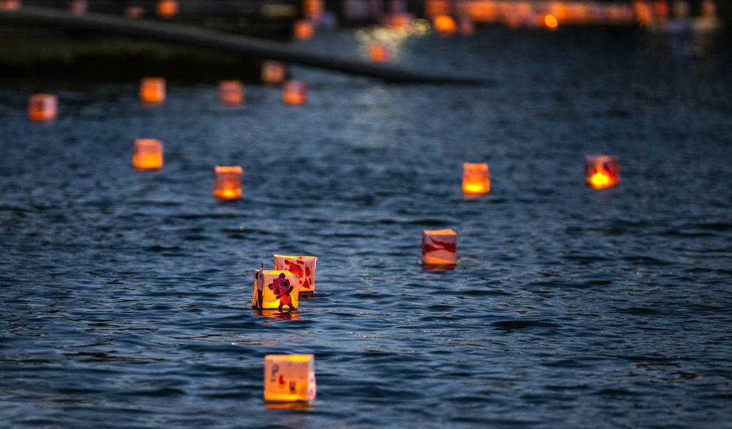 Lanterns float across the lake during the Water Lantern Festival at Sunset Park on Saturday, Ap ...