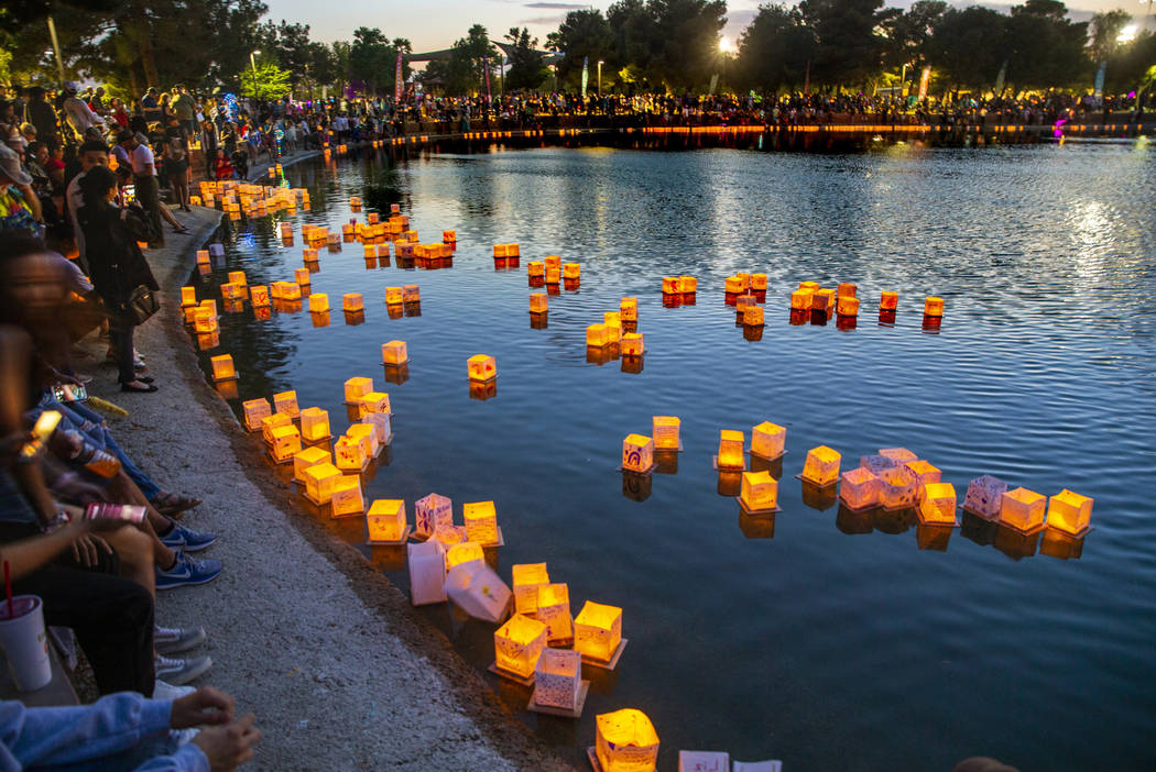 Lanterns gather near the lake edge as strong wings push them back during the Water Lantern Fest ...