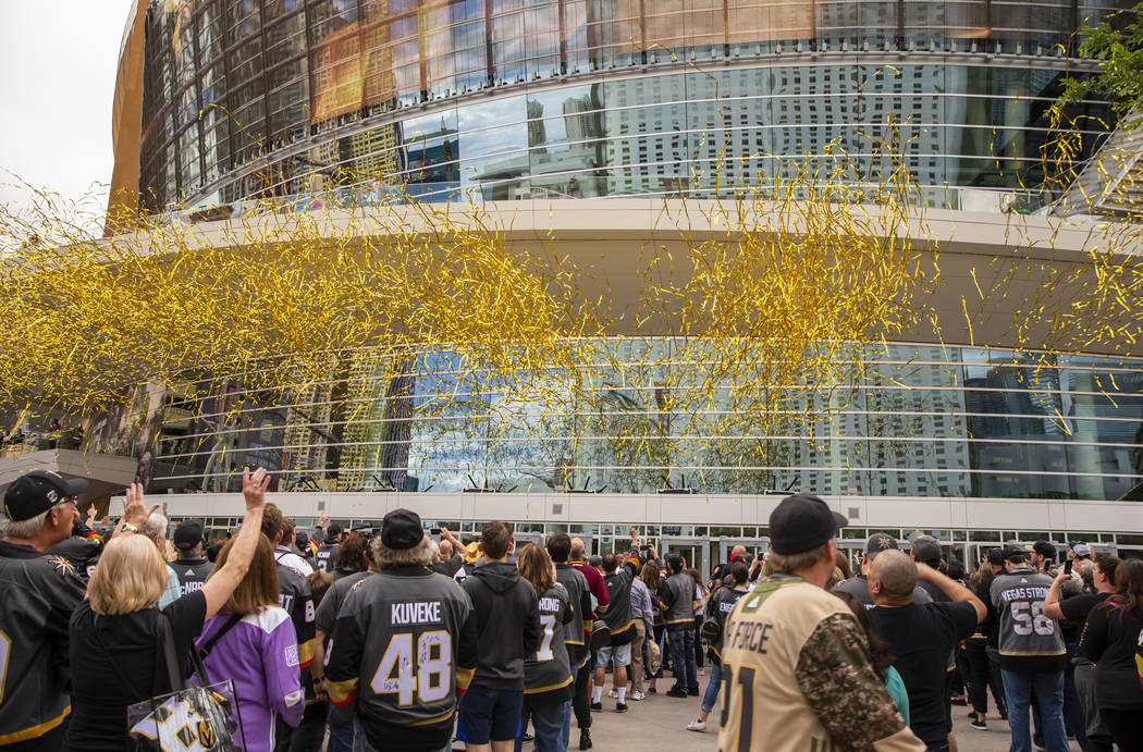 Confetti cannons blast over the crowd as they ready to enter the arena before the first period ...