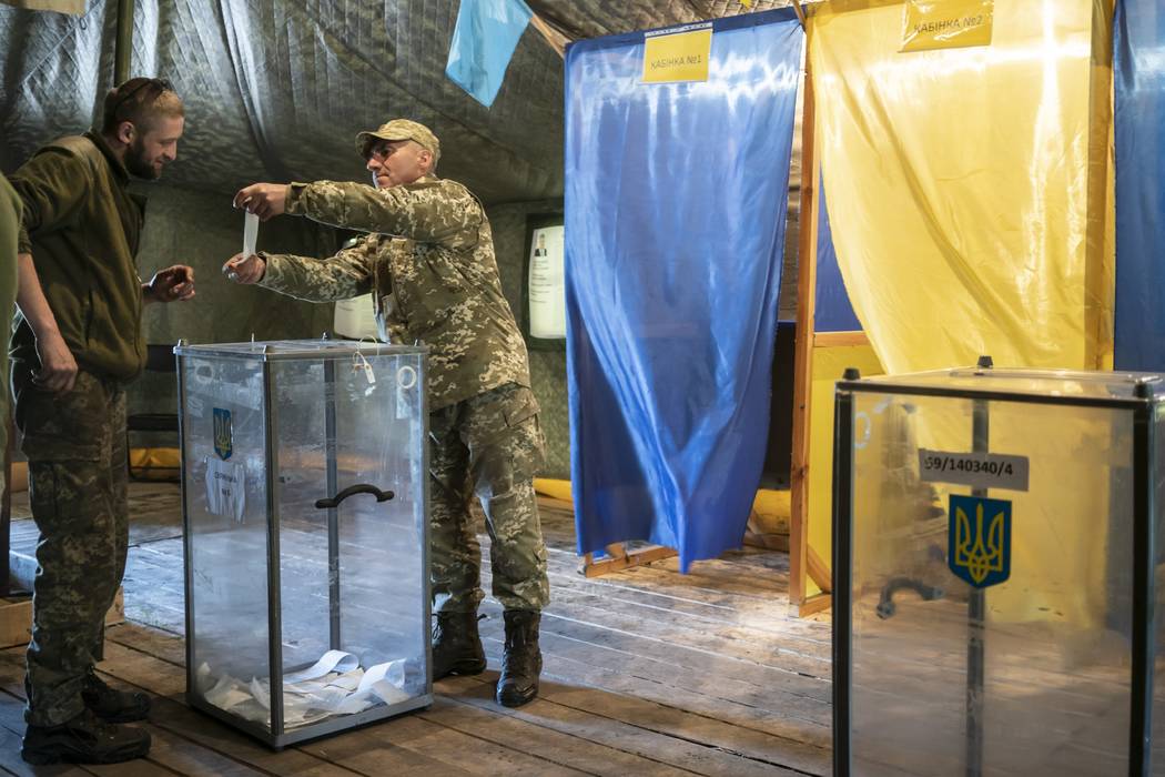 A Ukrainian government soldier demonstrates his ballot at a polling station, during the second ...