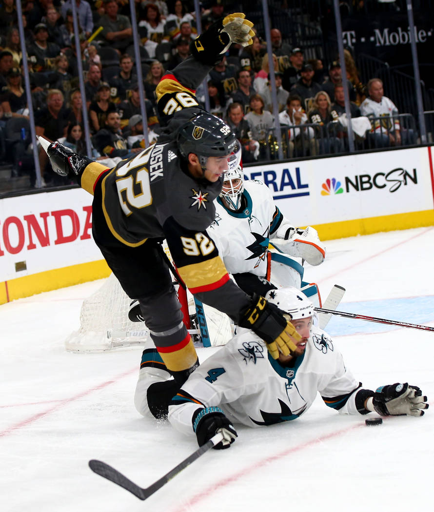 Golden Knights left wing Tomas Nosek (92) trips over San Jose Sharks defenseman Brenden Dillon ...