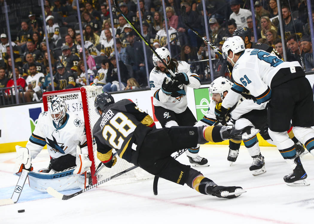 Golden Knights left wing William Carrier (28) tries to shoot as he falls to the ice in front of ...