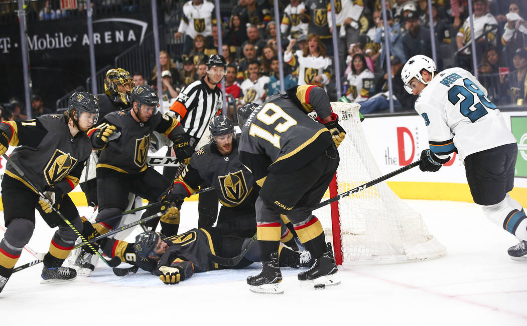 A phalanx of Golden Knights players surround the net in order to get the puck out as San Jose S ...