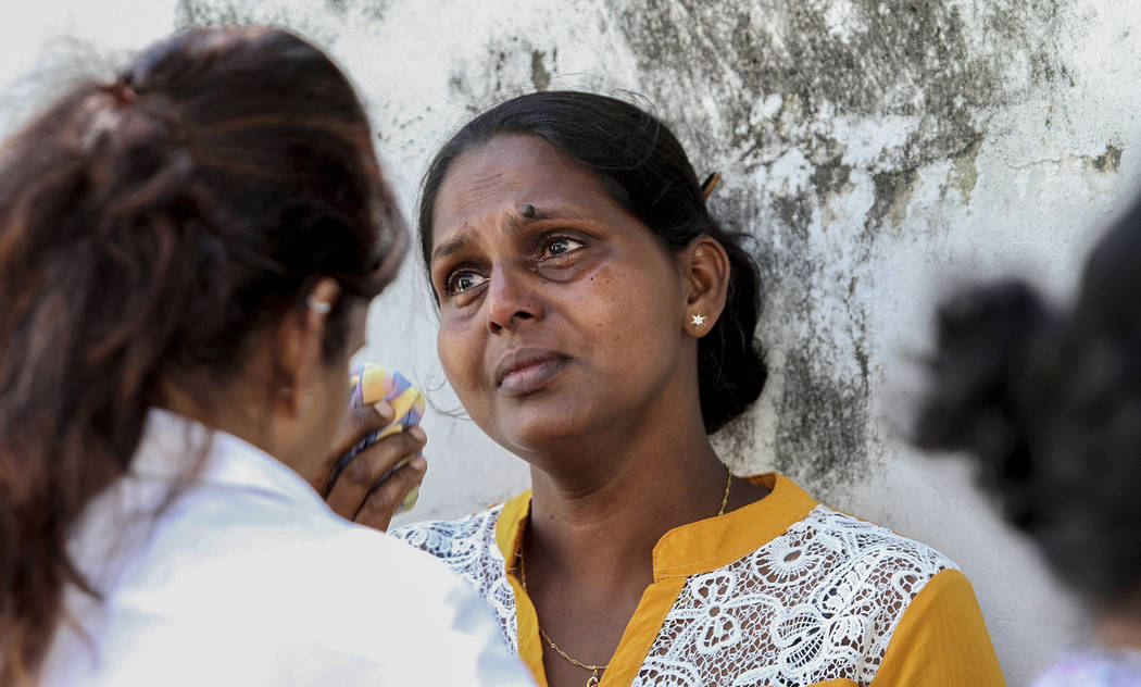 Relatives of serial blast victims mourn outside a police morgue in Colombo, Sri Lanka, Monday, ...