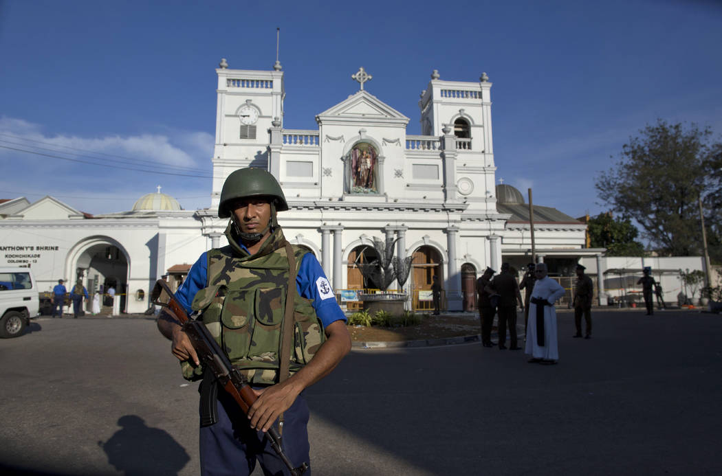 Sri Lankan air force officers and clergy stand outside St. Anthony's Shrine, a day after a blas ...