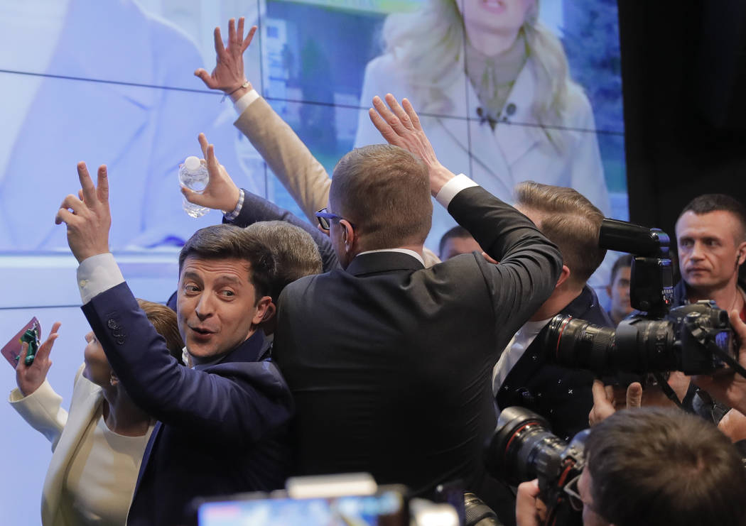 Ukrainian comedian and presidential candidate Volodymyr Zelenskiy, left, makes the victory sign ...