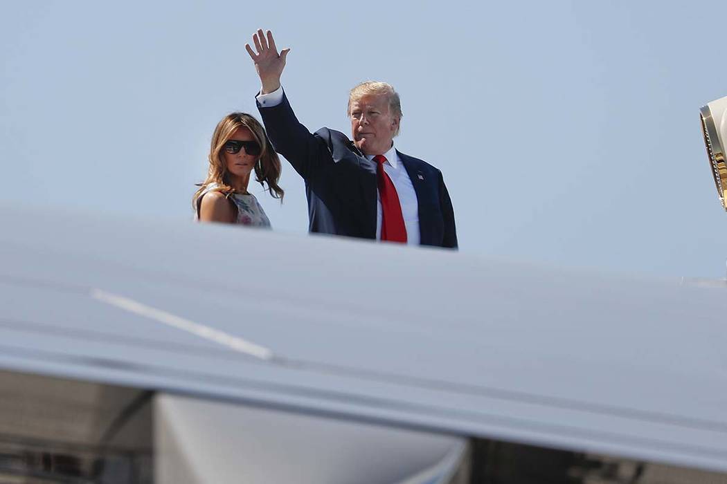 President Donald Trump, right, waves as he and first lady Melania Trump board Air Force One pri ...