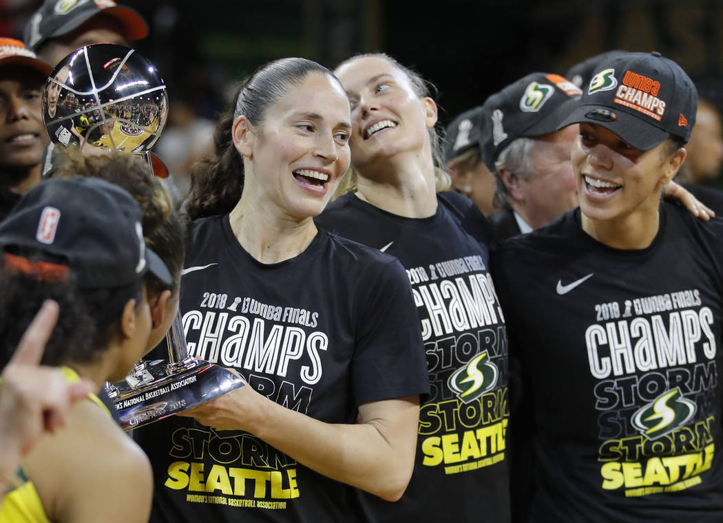 Seattle Storm guard Sue Bird, left, holds the championship trophy with her teammates during aft ...