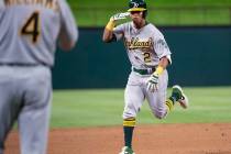 Oakland Athletics' Khris Davis (2) salutes third base coach Matt Williams (4) as he nears third ...