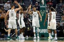 Milwaukee Bucks' Giannis Antetokounmpo gives high-fives to his teammates during the first half ...