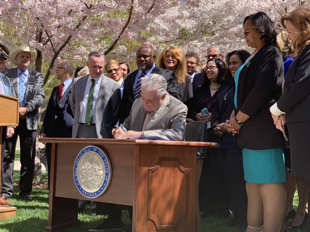 Nevada Gov. Steve Sisolak signs Senate bill 358, committing the state to run on at least 50 per ...