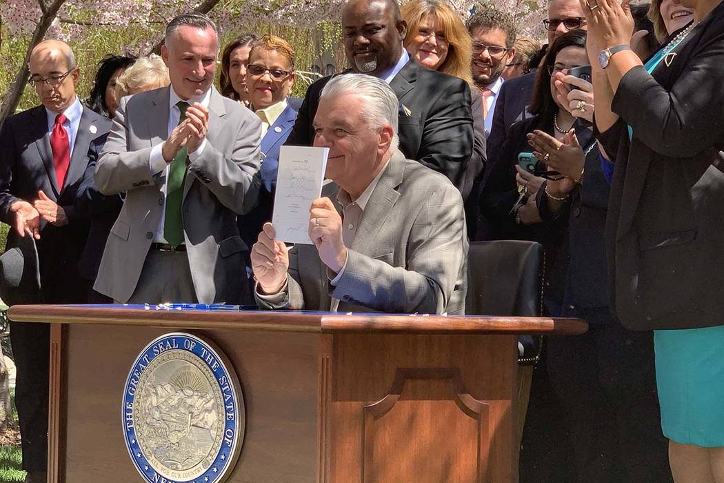 Nevada Gov. Steve Sisolak signs Senate bill 358, committing the state to run on at least 50 per ...