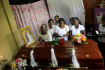 A Sri Lankan family mourns next to the coffin of their family member, a victim of Easter Sunday ...