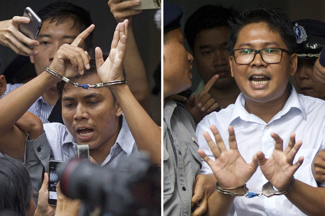 Reuters journalists Kyaw Soe Oo, left, and Wa Lone, are handcuffed as they are escorted by poli ...