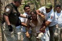 A Central American migrant is detained by Mexican immigration agents on the highway to Pijijiap ...