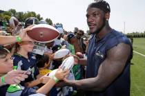 Seattle Seahawks defensive end Frank Clark signs autographs following NFL football training cam ...