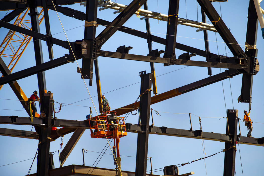 The newest truss is lowered into place and attached by awaiting steelworkers at the top of Raid ...