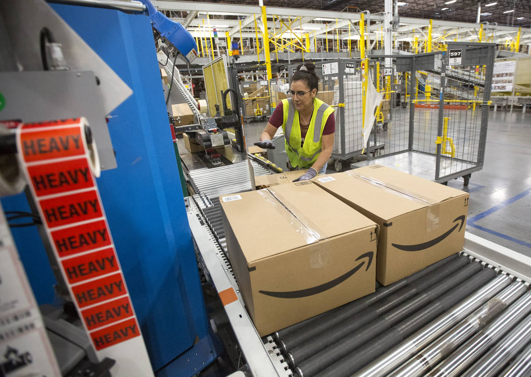 Sandee Moore packs customer orders moving on a conveyor belt at Amazon's North Las Vegas fulfil ...