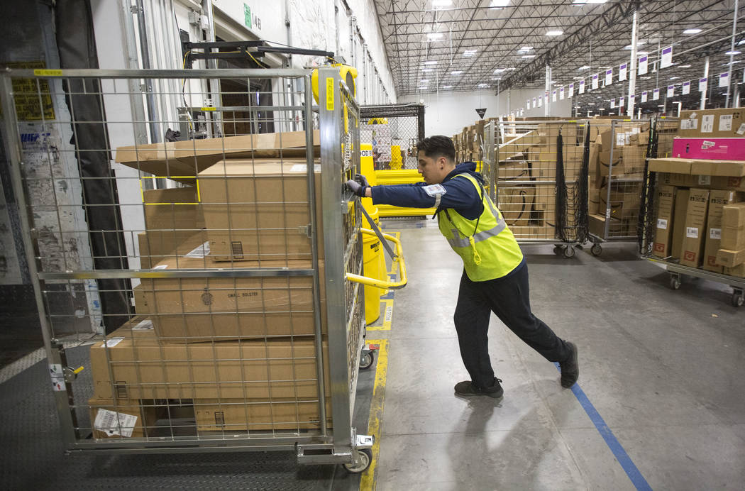 Eloy Zamudio loads customer orders onto a semitrailer at Amazon's North Las Vegas fulfillment c ...