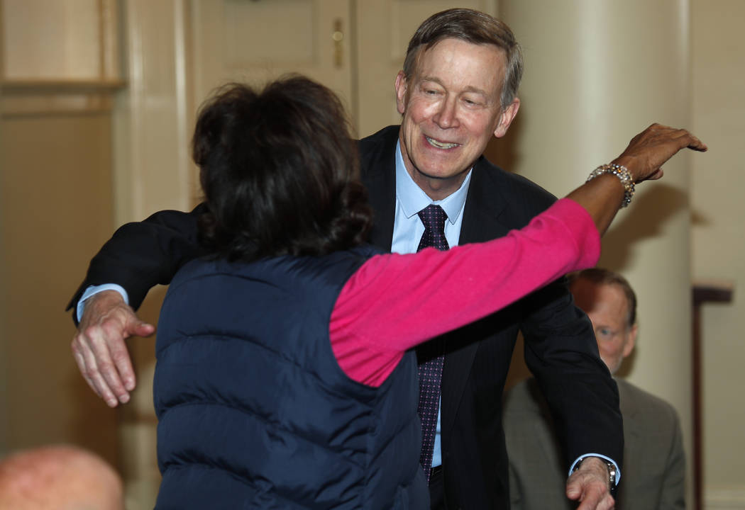 Democratic presidential hopeful John Hickenlooper, back, hugs Colorado state Sen. Rhonda Fields ...