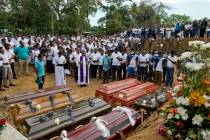 A priest conducts religious rituals during a mass burial for Easter Sunday bomb blast victims i ...