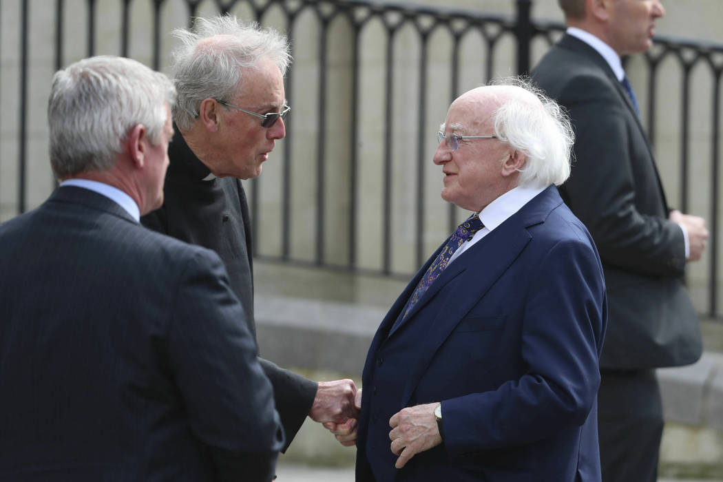 Irish President Michael D Higgins, right, arrives for the funeral service for journalist Lyra M ...