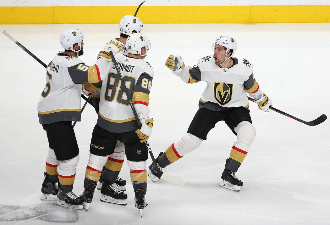 Knights right wing Mark Stone (61) celebrates with Knights defenseman Nate Schmidt (88) and Kni ...