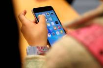 A child holds an Apple iPhone 6S on Sept. 25, 2015, at an Apple store on Chicago's Magnificent ...