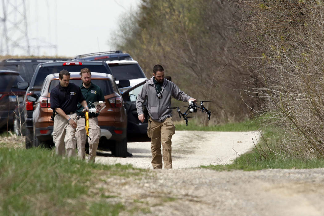 McHenry County Sheriff's officers and other law enforcement search the area of Route 176 and De ...