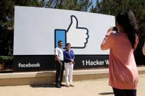 Visitors take photos in front of the Facebook logo Aug. 31, 2016, outside of the company's head ...