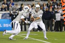 UNR quarterback Cody Fajardo (17) hands the ball off to running back Don Jackson (6) against Br ...