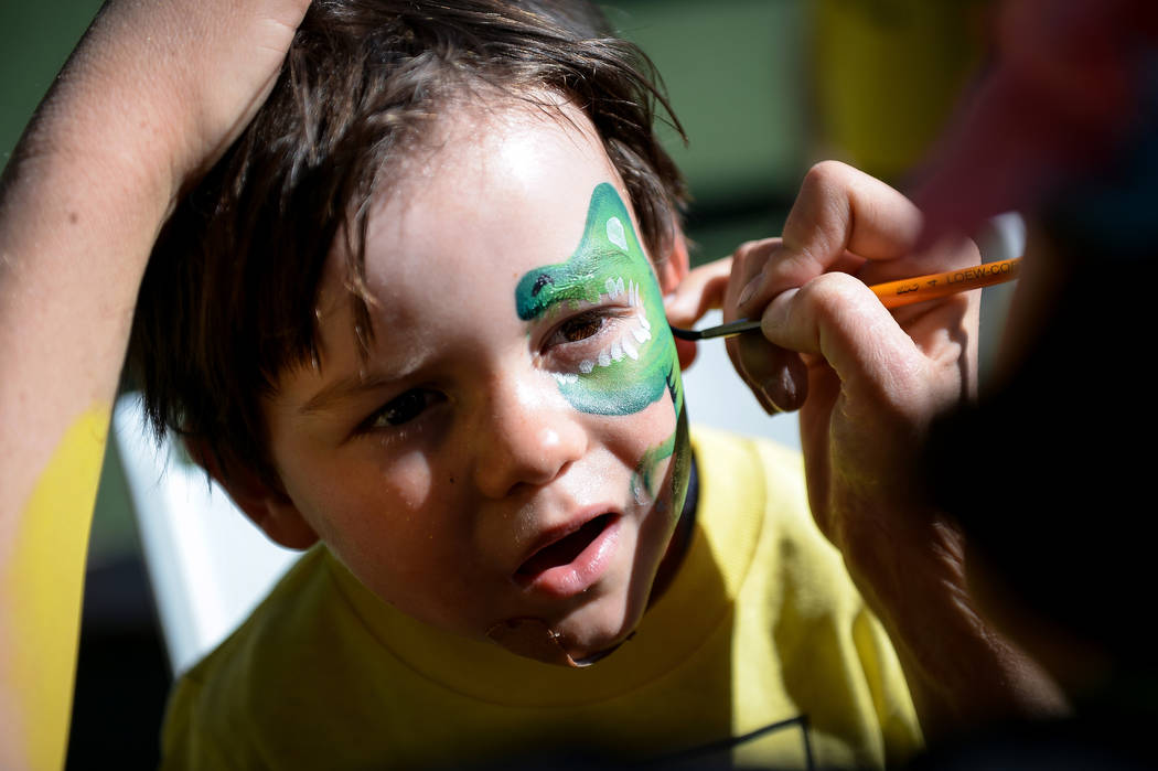 Valor Hook, 3, from Las Vegas gets a dinosaur painted on his face during the Anti-Defamation Le ...
