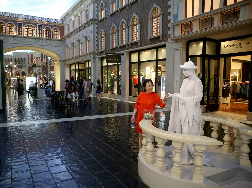 Judy Guo of Canada greets a living statue at The Venetian on the Strip in Las Vegas Thursday, A ...