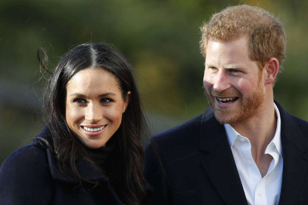 FILE - In this Dec. 1, 2017 file photo, Britain's Prince Harry and his fiancee Meghan Markle ar ...