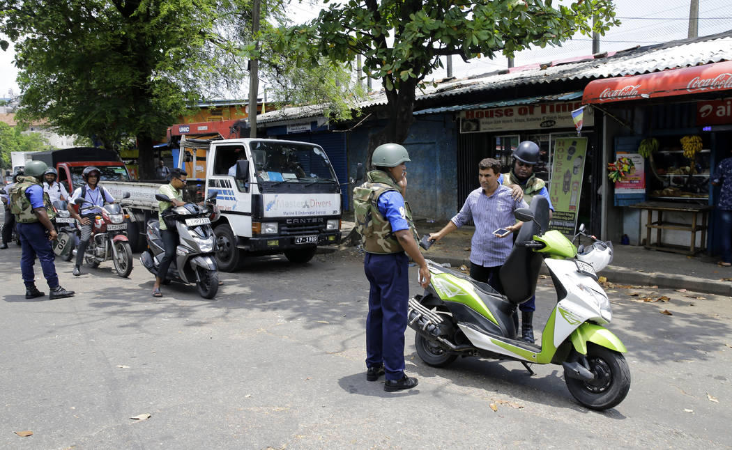 Sri Lankan navy soldiers perform security checks on motorists at a road in Colombo, Sri Lanka, ...