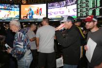 Fans lined up to place their bets during the first day of the NCAA basketball tournament at the ...