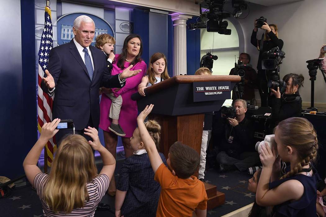 Vice President Mike Pence, left, joins White House press secretary Sarah Sanders, in pink, duri ...