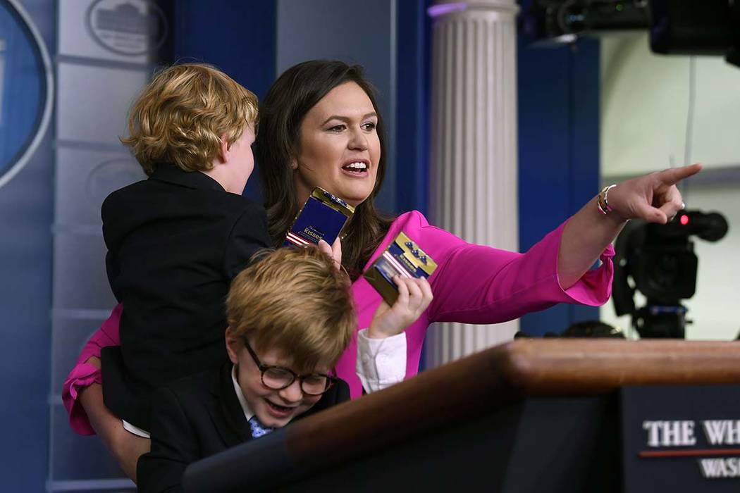 White House press secretary Sarah Sanders, holding her son George and standing next to her son ...
