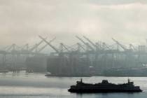 FILE - In this Dec. 31, 2018, photo a Washington state ferry sails on a foggy day near cranes a ...