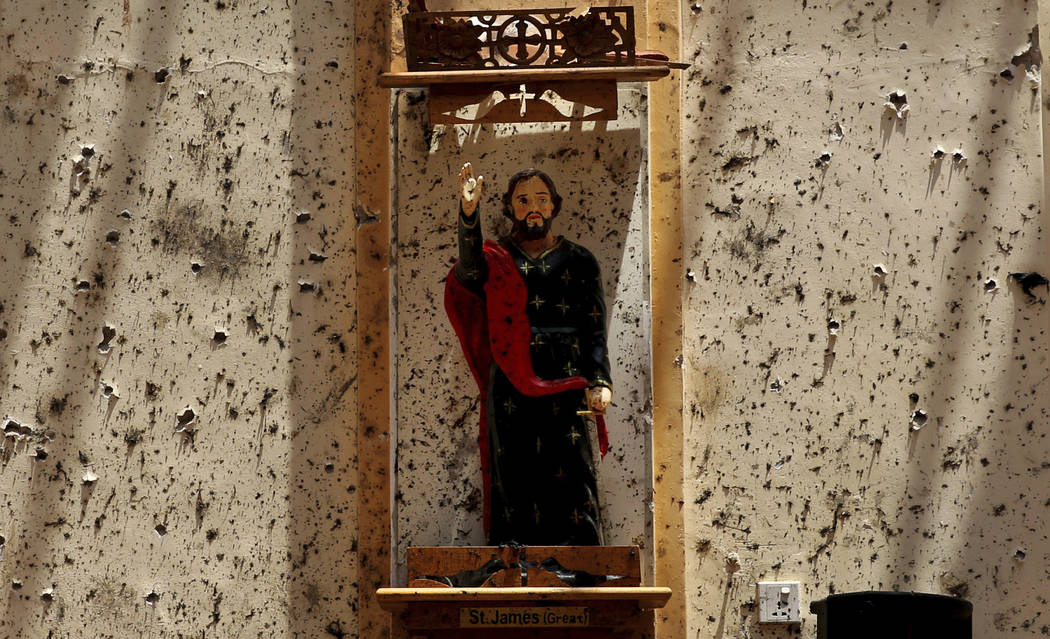 In this Thursday, April 25, 2019 photo, a statue of St. James stands on a wall speckled with fr ...