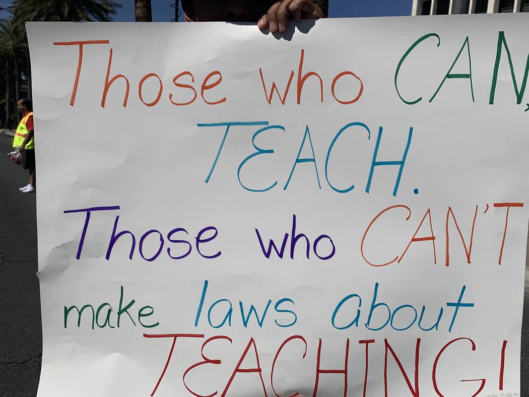 Derrick Chan, a 30-year-old PE teacher at Paradise Elementary School holds a sign during a rall ...