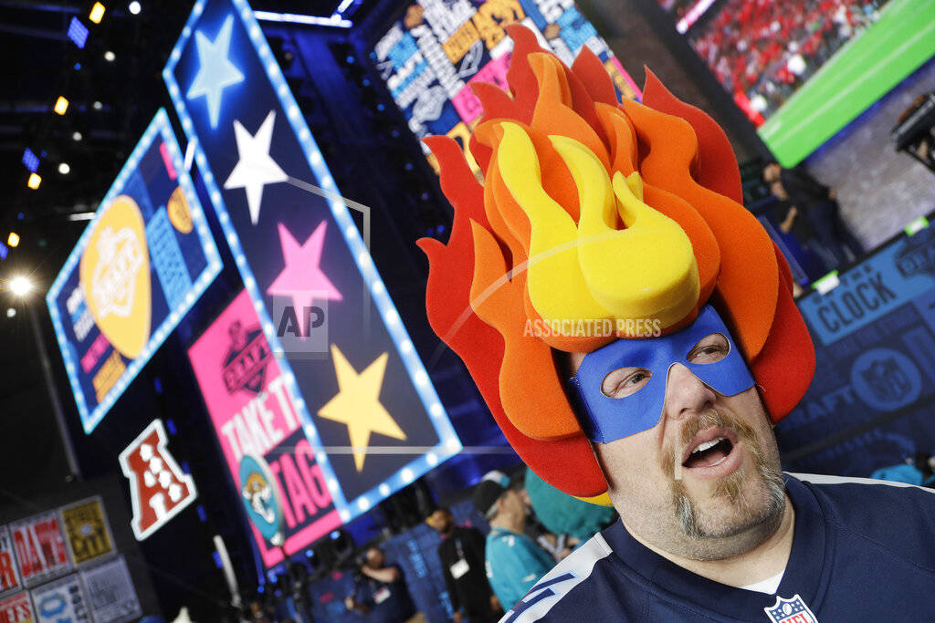John Davies, of Nashville, Tenn., walks on the main stage before the first round of the NFL foo ...