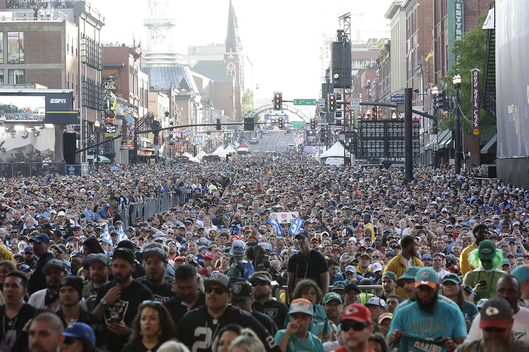Fans stand near the main stage ahead of the second round of the NFL football draft, Friday, Apr ...