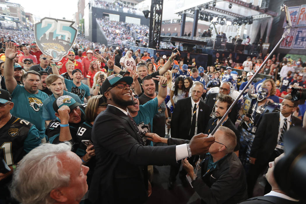 Florida's Jawaan Taylor takes a photo with fans after the Jacksonville Jaguars selected Taylor ...