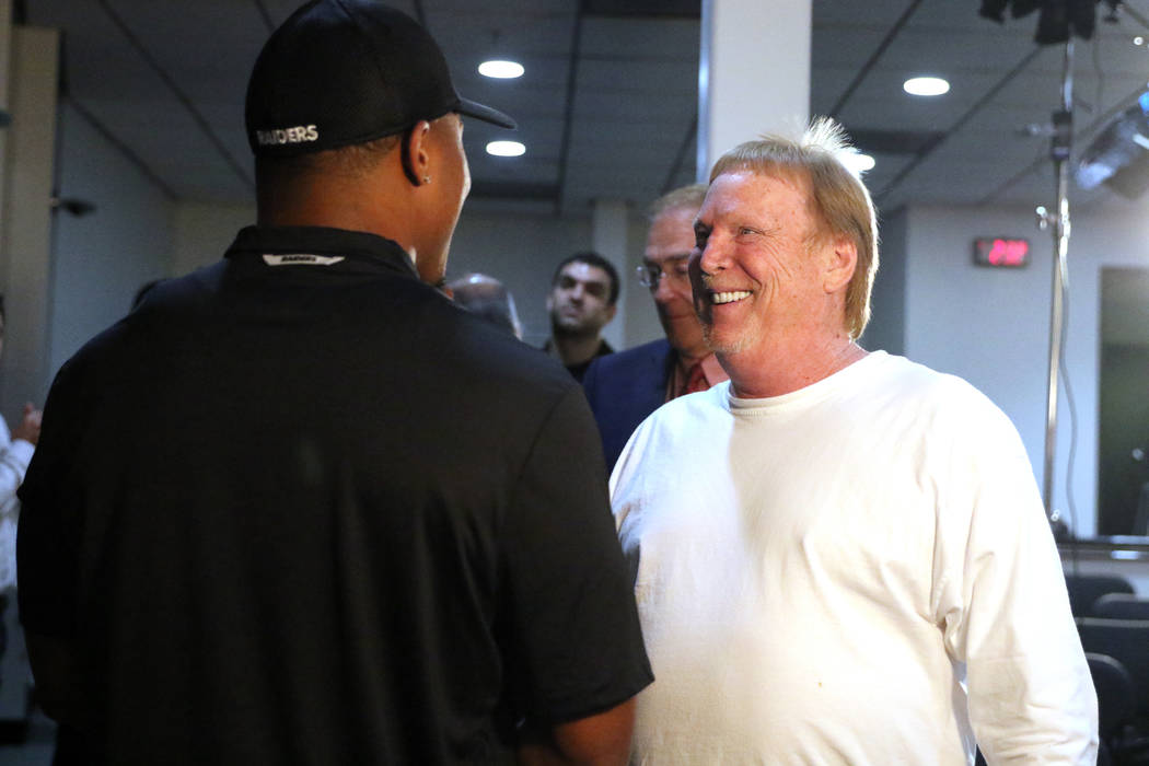 Oakland Raiders running back Josh Jacobs shakes hands with owner Mark Davis, right, after a new ...