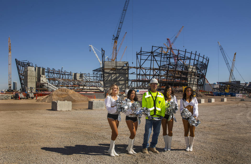 Labor concrete foreman Dave Durbin is flanked by the Raiderettes as he helps the Raiders announ ...