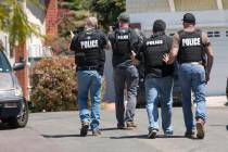 Heavily armed San Diego police officers approach a house thought to be the home of 19 year-old ...