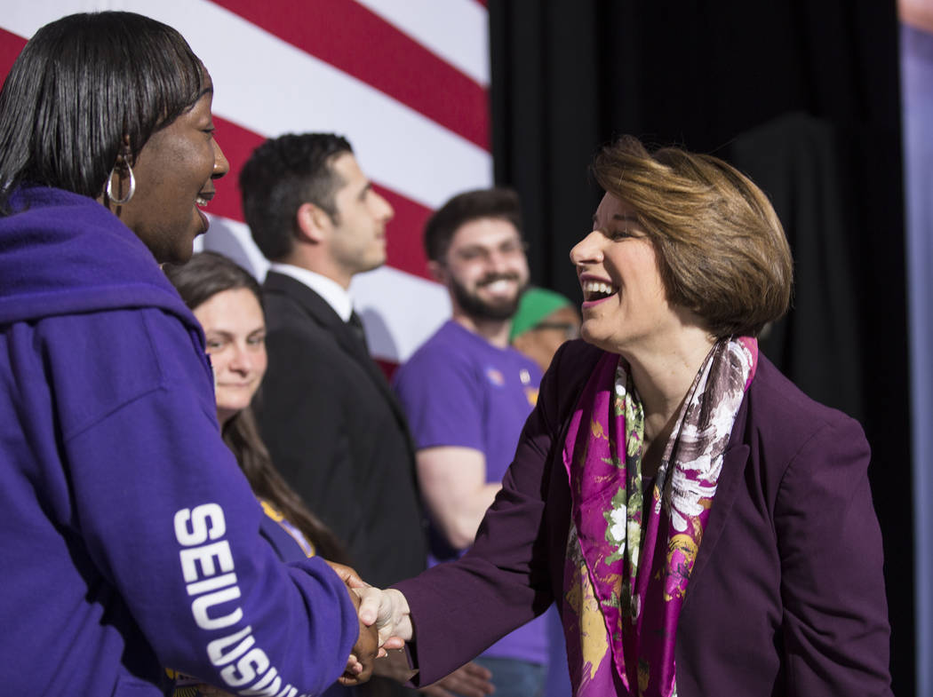 Presidential candidate Sen. Amy Klobuchar, right, D- Minn., shakes hands with supporters during ...