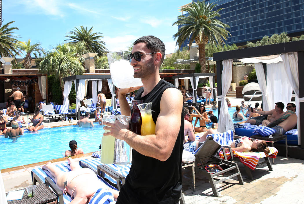 Talih Kadi, model cocktail server, carries drinks as he prepares to serve guests at M Resort Sp ...