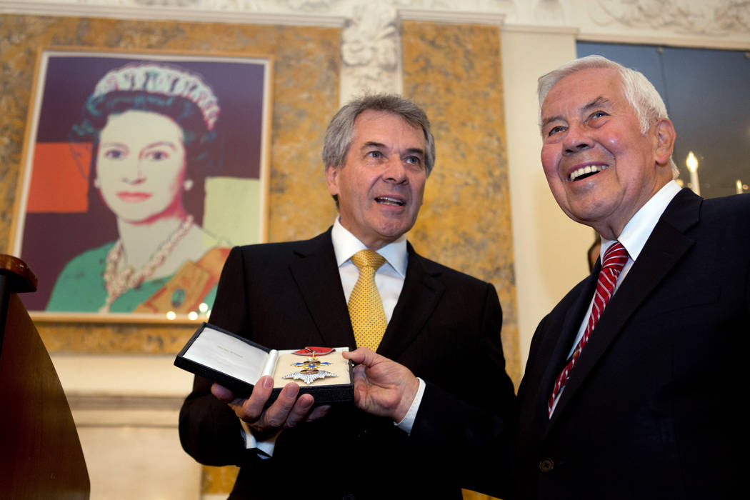 Peter Westmacott, British Ambassador to the U.S., left, presents former Indiana Republican Sen. ...